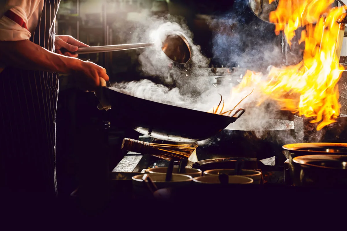 A chef tossing a flaming wok